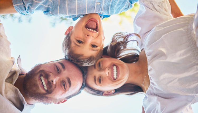 Eltern und Kind stehen im Kreis und genießen einen entspannten Familientag in den Osterferien.
