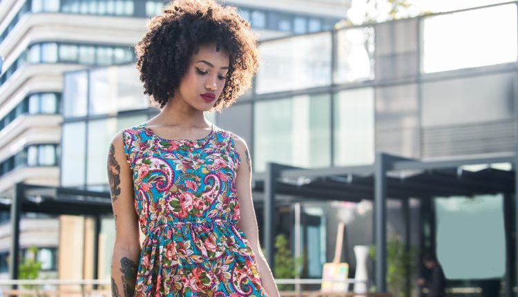 Frau im Paisley-Sommerkleid ohne Ärmel vor warmen Sonnenlicht